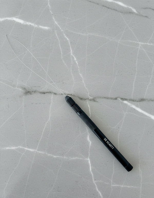 A black stylus pen with white text reading 'BE READY' lies diagonally on a light gray marble-patterned surface.
